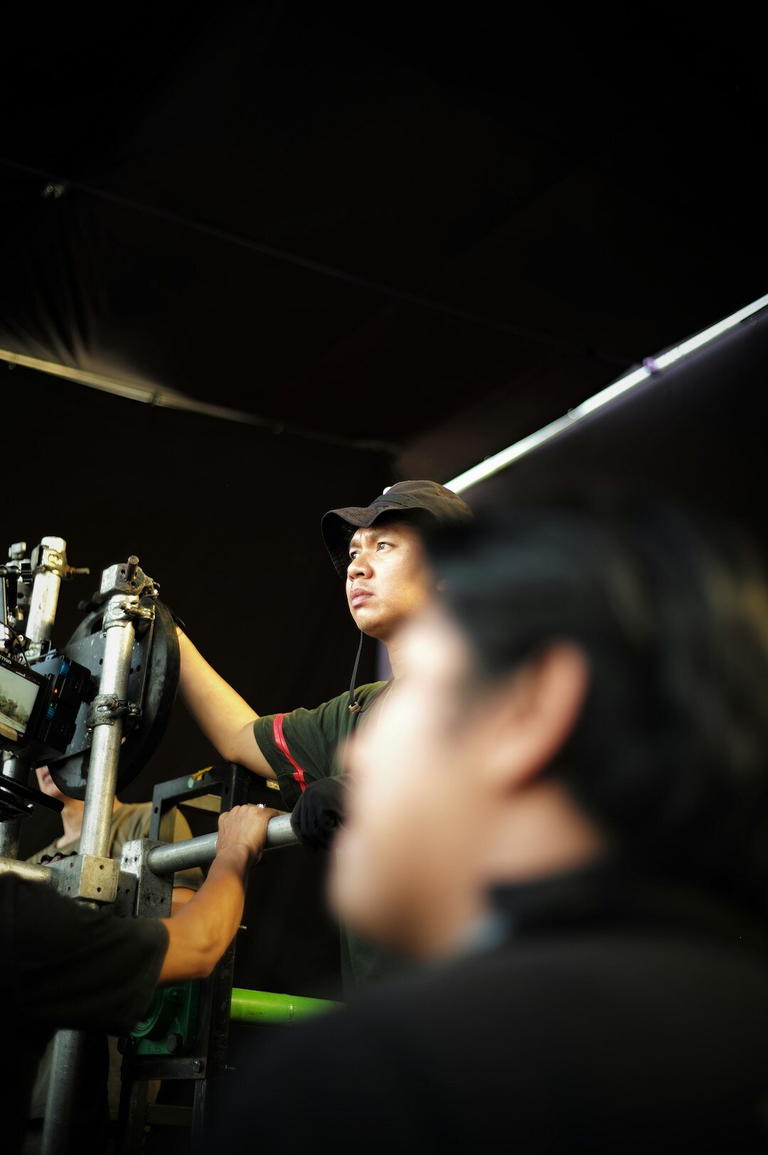 Technician setting up professional studio camera and lighting rig before a broadcast