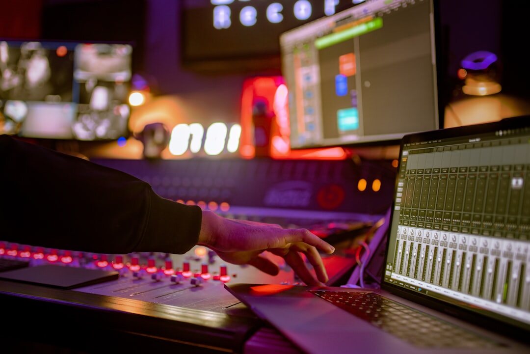 Sound engineer adjusting audio mixing console faders in a studio